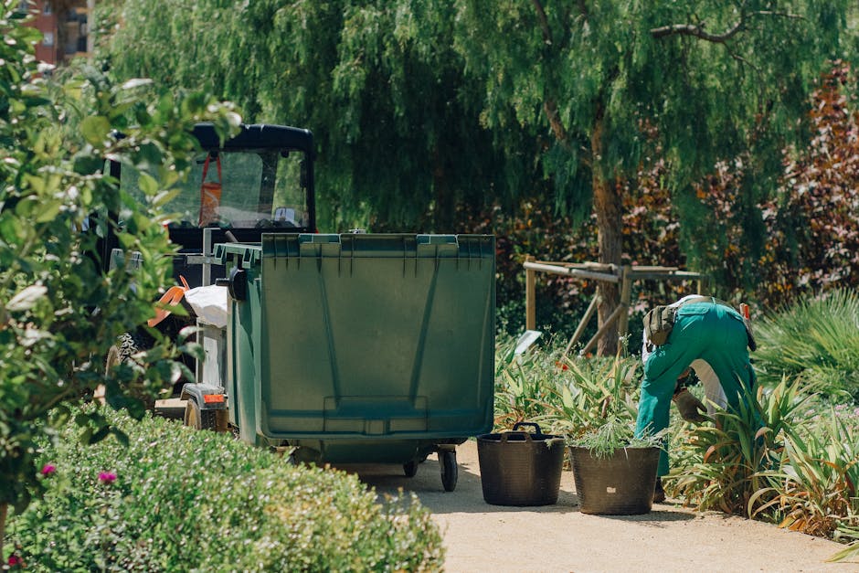 Landscaper measuring garden space with a tape measure while discussing project details with a homeowner.